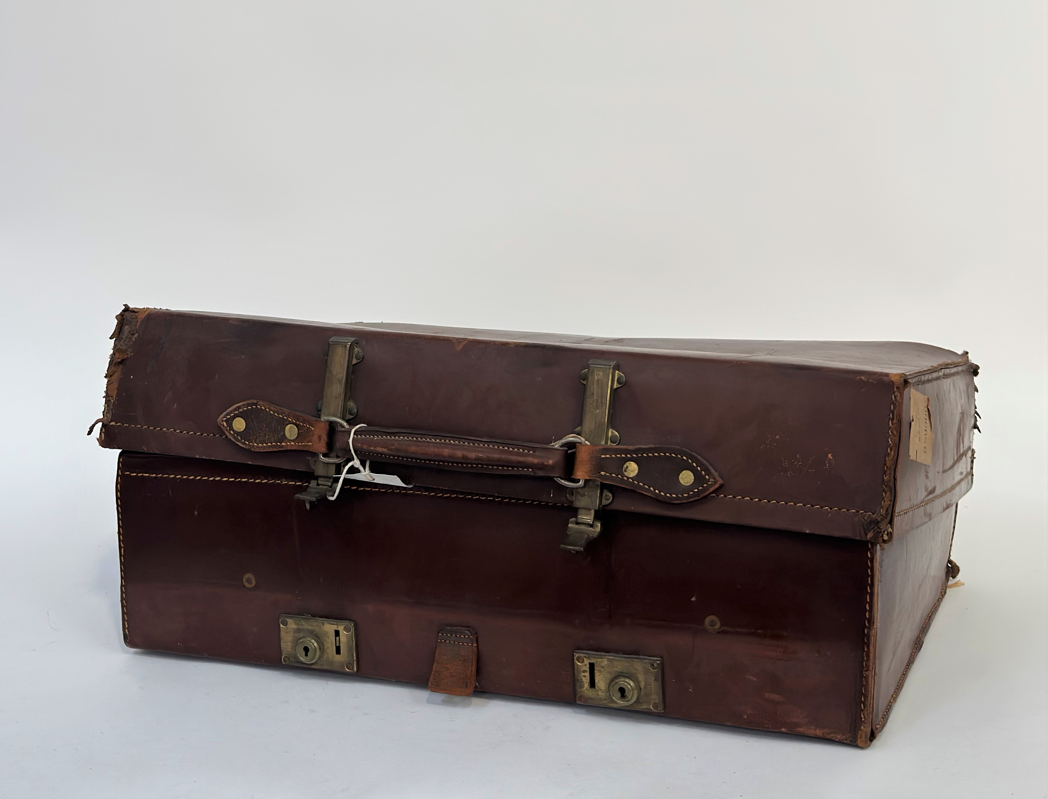 A early 20thc brown leather suitcase with brass locks, with linen fitted interior and leather