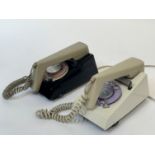 A pair of two toned trim dial phones, one with a black base and beige phone the other with a cream