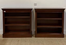 A pair of Georgian style mahogany open bookcases, with cross banded tops over dentil cornice over