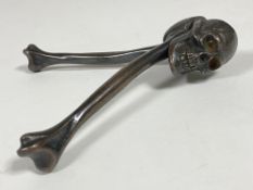 An early 20th century bronze nutcracker, formed as a skull and bones, stamped HJB Rd. 740410 L16cm
