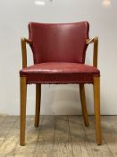 A 1940's beech framed open arm desk chair upholstered in red vinyl H83cm