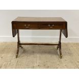 An Edwardian mahogany sofa table, the cross banded and strung top with two drop leaves and reeded