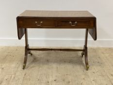 An Edwardian mahogany sofa table, the cross banded and strung top with two drop leaves and reeded