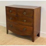 A Georgian mahogany bow front chest, fitted with two short and two long drawers, raised on splayed