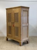 A 19th century and later pine cupboard, twin panelled doors enclosing an interior fitted for