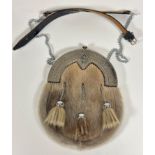 An Epns sealskin sporran with Celtic knop and thistle mounted top, fitted three plated tassels,