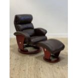 A Danish style reclining easy chair, upholstered in brown leather, raised on a circular swivel