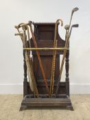 A Victorian oak and brass mounted stick stand, with galleried top over three division brass rail,