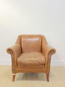 A club armchair, upholstered in tan brown studded leather, raised on square tapered and splayed