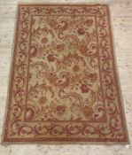 A flat weave tapestry style rug, retailed by Laura Ashley, the beige field with claret red