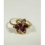 An 18ct gold marquise cut ruby (0.15ct) and two stone diamond floral cluster ring, in open