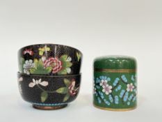 A pair of Chinese cloisonne bowls decorated with flowers against a black ground with manji