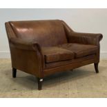 A contemporary two seat sofa, upholstered in tan brown studded leather, raised on square tapered and