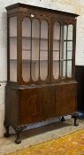 A George III style mahogany bookcase, two glazed doors opening to two fixed shelves, twin panelled