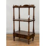 A Victorian three tier walnut whatnot, the three quarter galleried top raised on turned supports,