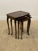 A 1930's walnut nest of three tables, with scalloped edge to top, raised on cabriole supports.
