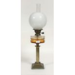 A late 19th/ early 20th century oil lamp, the gilt brass reeded column on a stepped square base