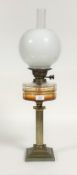 A late 19th/ early 20th century oil lamp, the gilt brass reeded column on a stepped square base