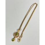 An Edwardian 9ct gold peridot and seed pearl crescent drop pendant, on trace link chain (pendant: