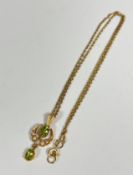 An Edwardian 9ct gold peridot and seed pearl crescent drop pendant, on trace link chain (pendant: