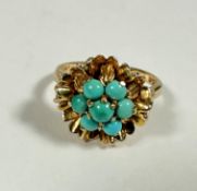 A 9ct gold 1970s style dress ring mounted five circular turquoise cabouchons in floral style setting