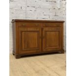 An Edwardian walnut sideboard, the ledge back over two drawers and two panelled cupboards, raised on