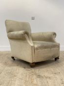 An early 20th century walnut framed upholstered armchair, with a racked back and deep seat, above