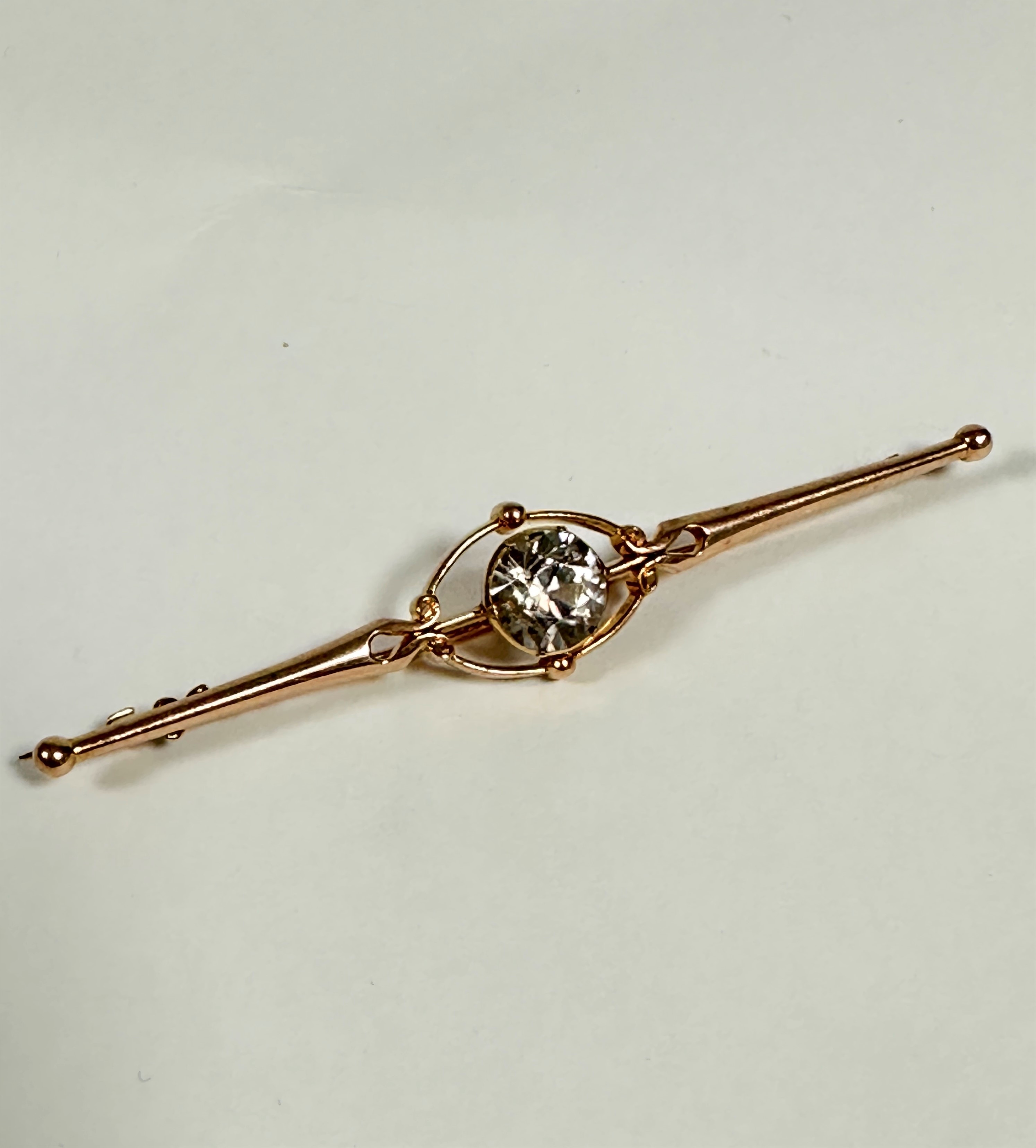 An unmarked but tested 9ct gold Edwardian bar brooch set natural zircon (1.5ct), with open oval