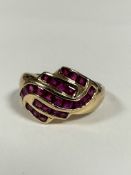A 9ct gold scrolling calibre set ruby dress ring of scrolling form (P/Q) (3.52g)