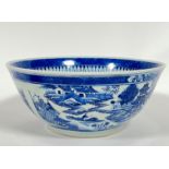 A large Chinese blue and white punch bowl painted with scenes of pagoda and houses to the