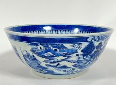 A large Chinese blue and white punch bowl painted with scenes of pagoda and houses to the