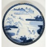 A 19th century Japanese blue and white plate decorated with scene of cranes and mountains, with