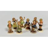 A group of nine miniature Hummel pottery figures including Little Hiker, Honour Student, First