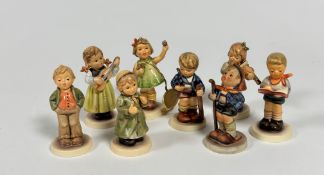 A group of nine miniature Hummel pottery figures including Little Hiker, Honour Student, First