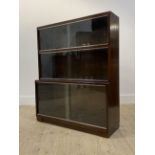 Minty, a mid 20th century mahogany three height stacking bookcase, each tier with twin sliding