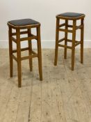 A pair of varnished beech bar stools, mid 20th century, with black vinyl seat pads, H72cm, W34cm,