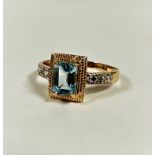 A modern 10ct gold dress ring mounted cushion cut aquamarine in yellow metal claw setting, flanked