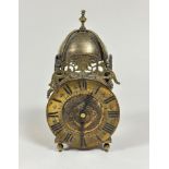 A reproduction brass lantern style clock with baluster finial and domed bell, with brass engraved