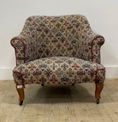 An early 20th century upholstered armchair, moving on castors. H76cm, W75cm, D80cm