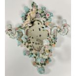 A 19thc porcelain Dresden style rococo scalloped frame wall mirror with scrolling leaf surmount