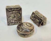 A group of three silver pill boxes comprising: one in Edwardian style stamped with winged putti,