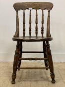A Victorian vernacular mahogany chair, with spindle back over circular seat, raised on turned