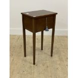 An Edwardian inlaid mahogany sewing table, the hinged top opening to a fitted interior, raised on