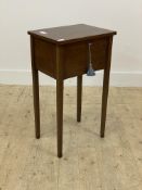 An Edwardian inlaid mahogany sewing table, the hinged top opening to a fitted interior, raised on