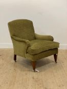 An Edwardian style armchair, upholstered in green chenille fabric, with squab cushion, raised on