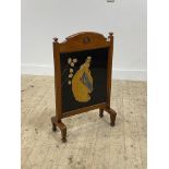 An early 20th century mahogany fire screen with poker work style painted panel H83cm, W53cm