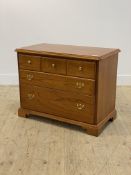 A Georgian style stained hardwood chest fitted with three short and two long graduated drawers,