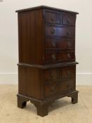 A Georgian style mahogany bedside chest in the form of a tall boy, fitted with two over three, and