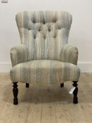 A Victorian style slipper chair, upholstered in buttoned cotton of geometric design, raised on