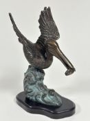 A San Pacific International American patinated cast bronze pelican figure mounted on hardwood